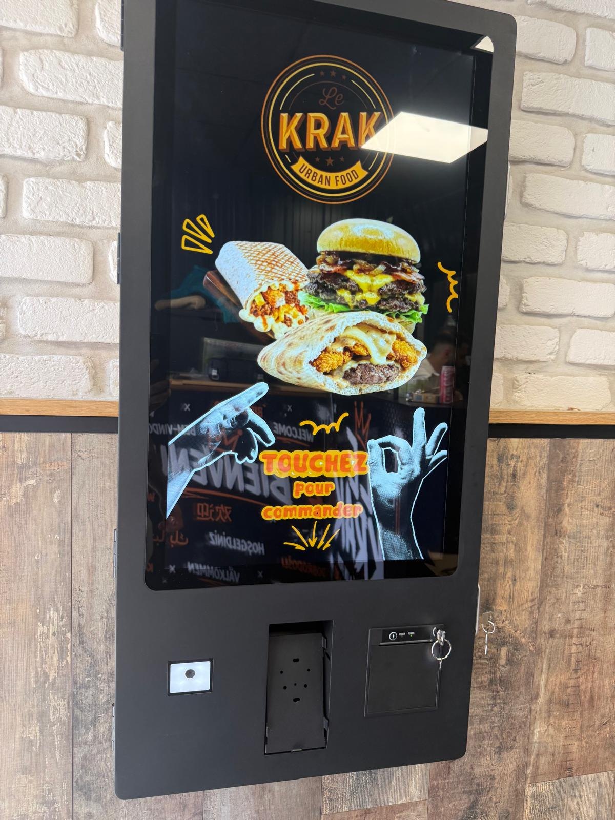 Borne de commande murale d'un restaurant de tacos et burgers, briques blanches