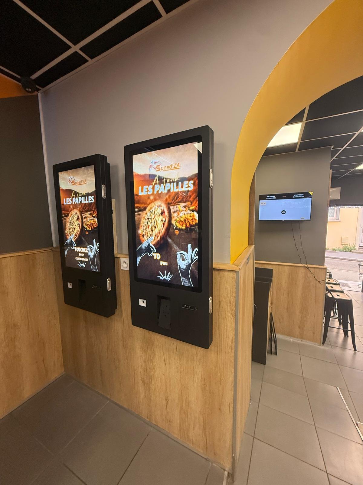 Deux bornes de commande murales vues de plus près, salle jaune et bois
